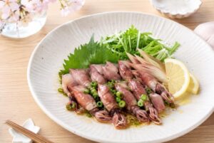 ホタルイカにねぎや大葉、みょうが、レモンを添えたさっぱり系の料理